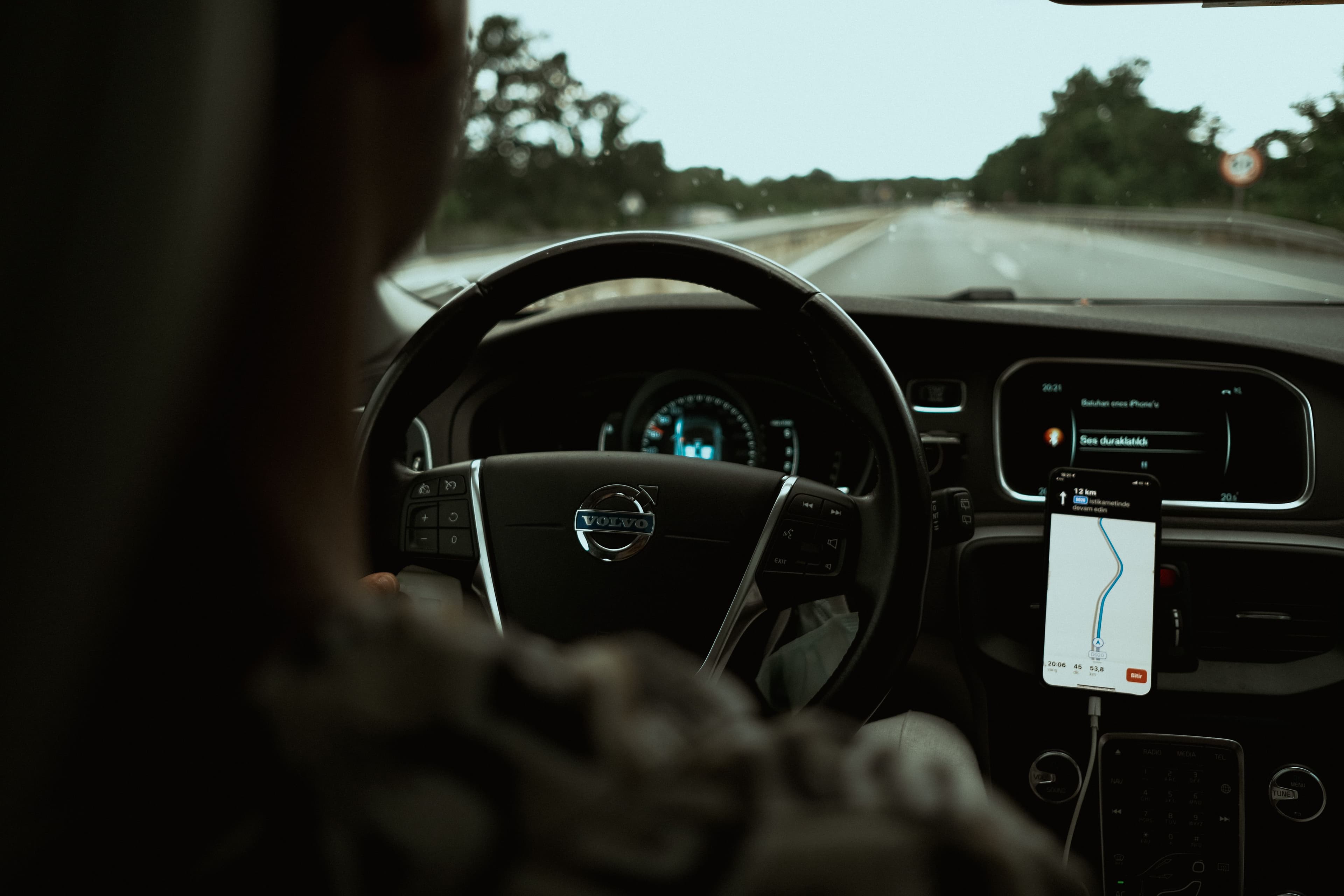 Chauffeur souriant montrant son téléphone avec l'application ouverte