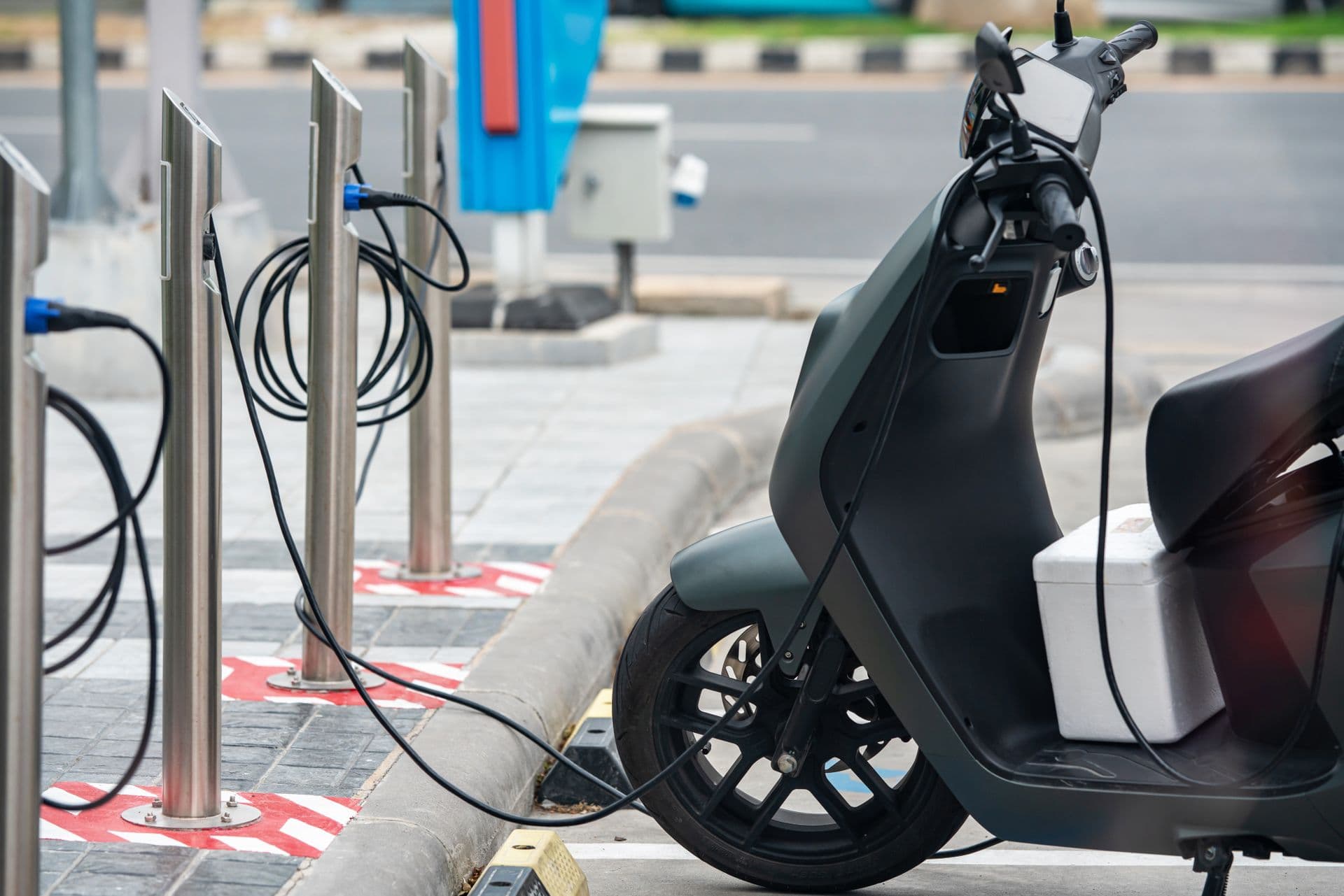 Une moto électrique branchée sur une borne de recharge en ville
